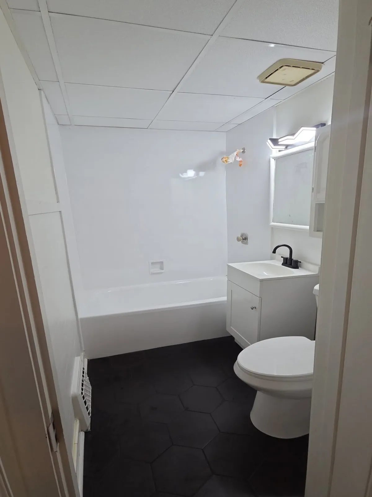 Bathroom remodel with black floor tile