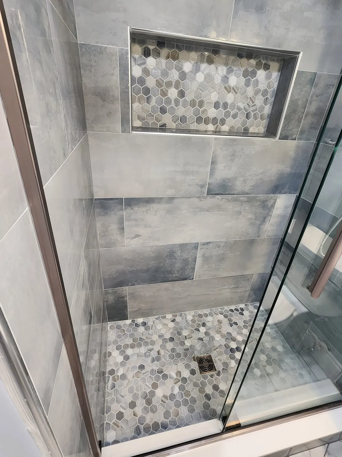 Hexagonal tile shower in a remodeled bathroom